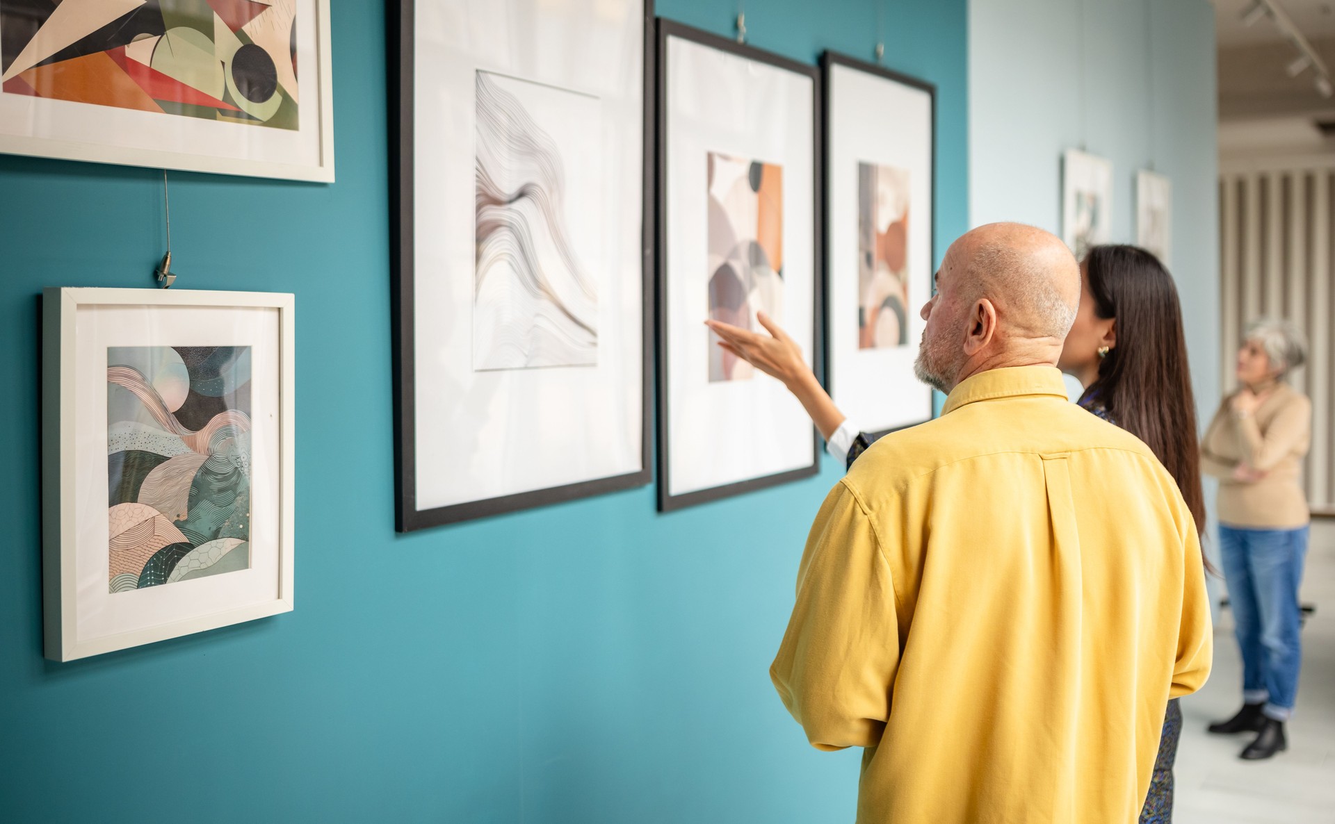 Visitors observing abstract artwork in a contemporary gallery exhibition